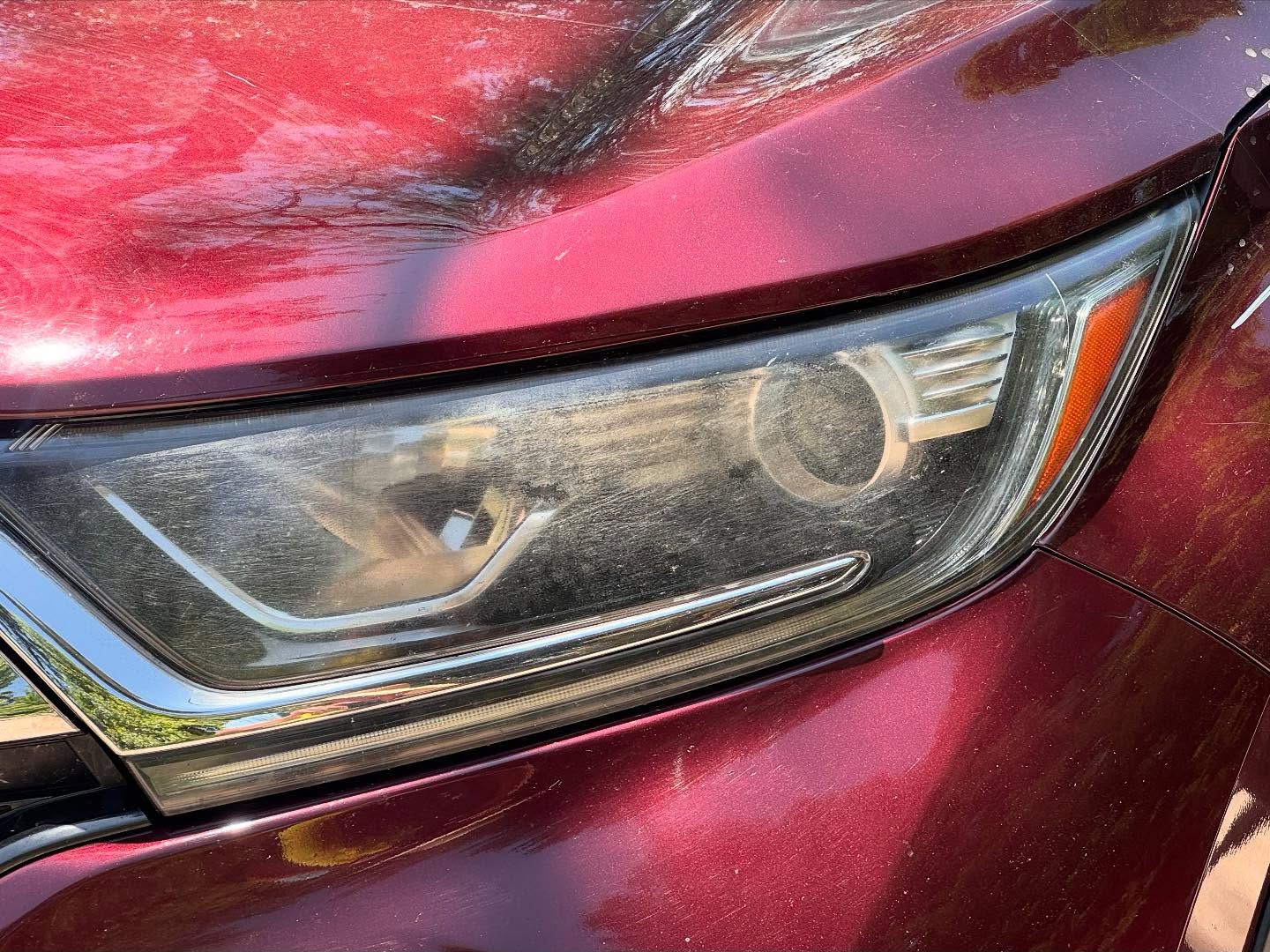 Foggy, dusty headlight on a red Honda CR-V before restoration